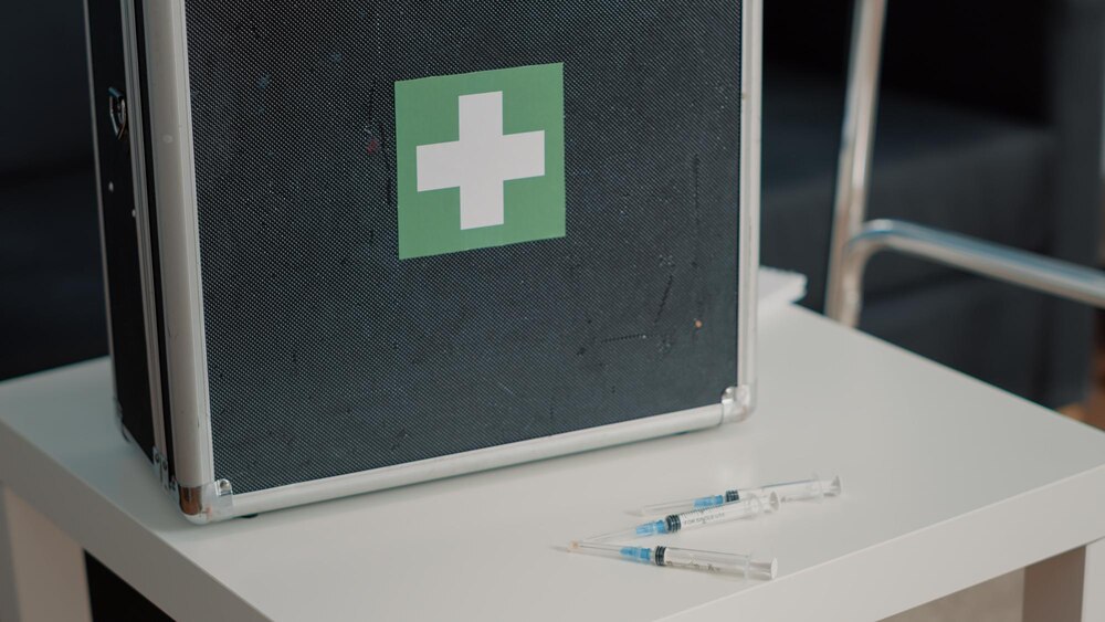 Close up of medical suitcase and syringes for healthcare on table in nursing home. Briefcase with tools and equipment for rehabilitation service and wellness. Injection and case