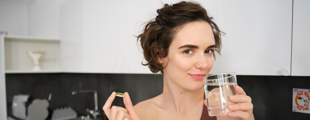 Dietry supplements and healthy lifestyle young woman taking vitamin c d omega with glass of water